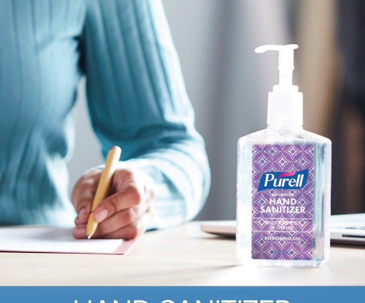 Hands rubbing in PURELL hand sanitizer gel at a table